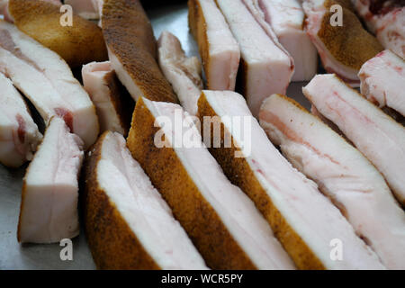 Vetrina con varietà di carni di greggio, la pancetta e il lardo sulla strada del mercato o mercato di fattoria. I prodotti a base di carne del negozio. Close-up. Foto Stock