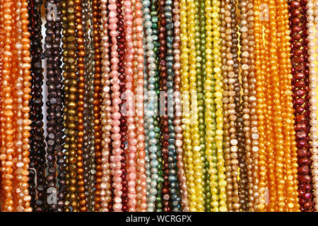 Close up molte stringhe di colorati collane di perle sul display di vendita al dettaglio a basso angolo di visione Foto Stock