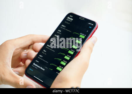 Bishkek, Kirghizistan - 5 Giugno 2019: Iphone in mano. Imprenditore tenendo iPhone X con applicazione di scorte di Apple. Foto Stock