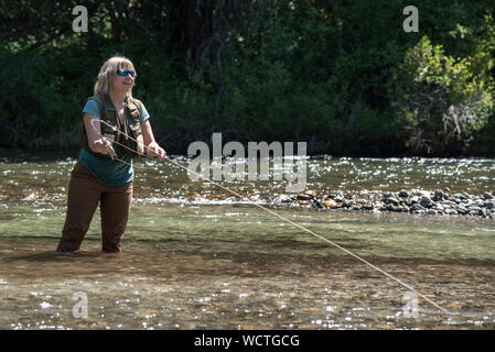 La donna la pesca nel Fiume Minam, Wallowa Mountains, Oregon. Foto Stock