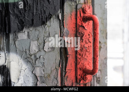 Il rosso vecchia maniglia della porta nella incerta Foto Stock