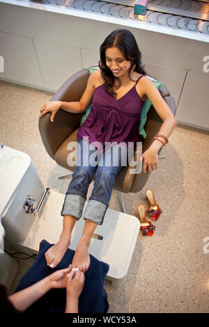 Sorridente metà donna adulta ottenendo un pedicure in un salone di bellezza. Foto Stock