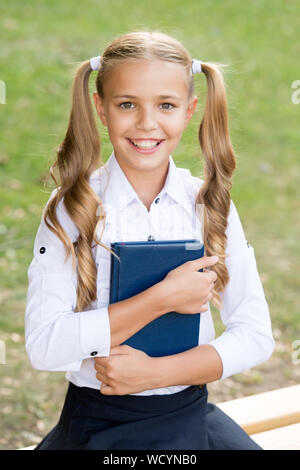 Studio della lingua. Scuola Educazione nozione. Carino piccolo bookworm. Giorno della conoscenza. Pronto per le lezioni. Studente della scuola secondaria. Carino sorridente bambino piccolo libro di attesa. Adorabile bambina studente della scuola. Foto Stock