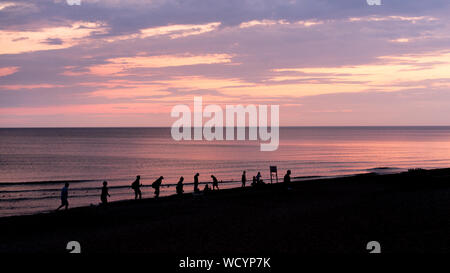 Spiaggia al tramonto con sagome di persone, Mar Baltico, Palanga, Lituania Foto Stock