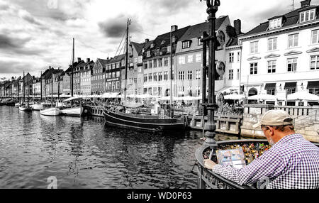 Barche colorate e le case con il pittore a Nyhavn Canal in Copenhagen DANIMARCA Foto Stock