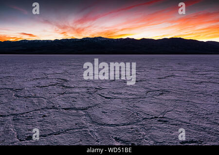 Spettacolare tramonto dietro il picco del telescopio nelle montagne Panamint visto da Badwater saline nel Parco Nazionale della Valle della Morte. Foto Stock