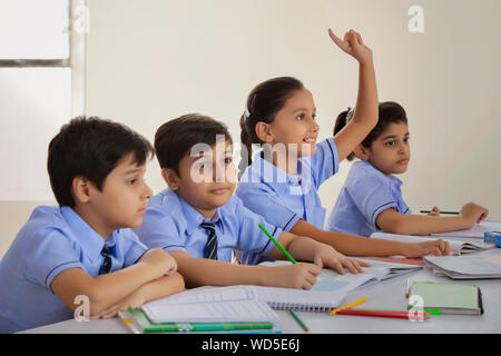 School girl per chiedere un dubbio nella classe Foto Stock