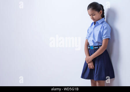 School girl in piedi in punizione Foto Stock