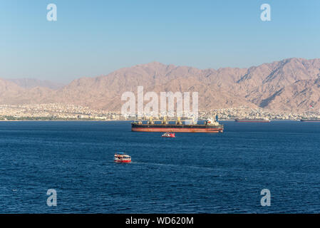 Eilat, Israele - 7 Novembre 2017: vista dal carico porto di Eilat in Israele sulle montagne giordane e navi ancorate nel golfo di Aqaba (Mar Rosso). T Foto Stock