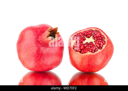 Tagliare e tutto il melograno rosso con semi di colore bianco su sfondo a specchio con la riflessione isolata da vicino Foto Stock