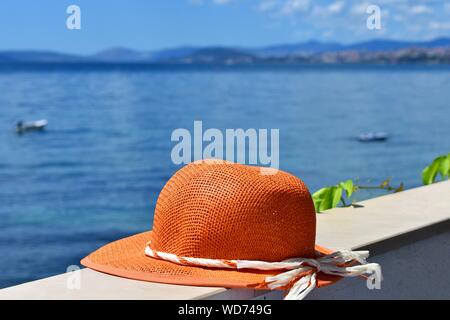 Donna cappello d'estate in terrazza con splendida vista sul mare al giorno d'estate e di sole/ immagine concettuale delle vacanze estive Foto Stock