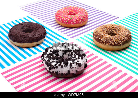 Diverse le ciambelle su un multi-colore di sfondo striato vista superiore Foto Stock