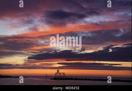 Il sole sorge sulla scultura " La Coppia " da artista Sean Henry, a Newbiggin-per-il-mare in Northumberland. Foto Stock