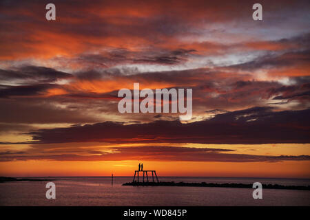 Il sole sorge sulla scultura " La Coppia " da artista Sean Henry, a Newbiggin-per-il-mare in Northumberland. Foto Stock