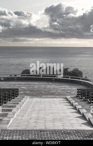 Immagine verticale di una scala in pietra che conduce in basso con mozzafiato grandi nuvole nel cielo Foto Stock