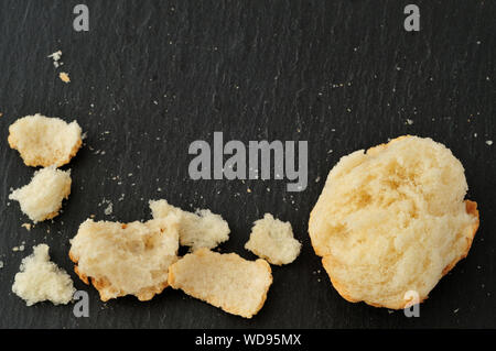 Il pangrattato e bit di pane spezzato, sulla piastra di ardesia da sopra, con spazio di copia Foto Stock