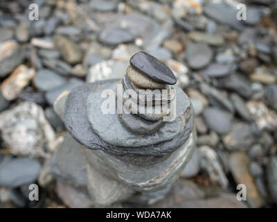 Cairn realizzato da ciottoli grigio su una spiaggia, Nuova Zelanda Foto Stock