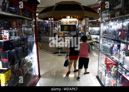 SAN JUAN, Metro Manila, Filippine - Agosto 21, 2019: i clienti passano da file di negozi di giocattoli e di uno snack bar all'interno di un centro commerciale. Foto Stock
