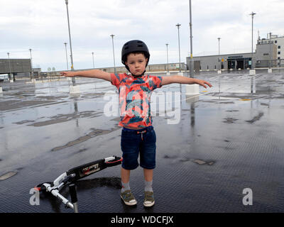 6 anno vecchio ragazzo giocando sulla spinta scooter Foto Stock