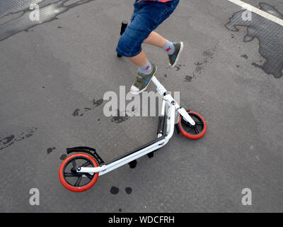 6 anno vecchio ragazzo giocando sulla spinta scooter Foto Stock