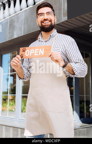 Il piacere gioioso uomo barbuto tenendo un cartello Foto Stock