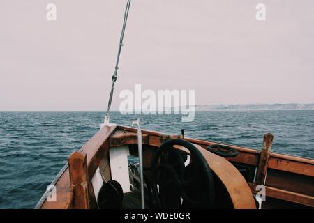 Bellissimo scatto di un arco della barca sul mare con colline e un nuvoloso sullo sfondo Foto Stock