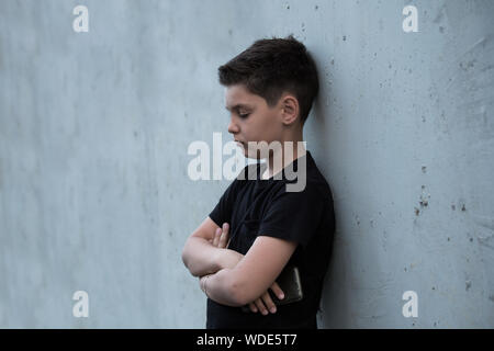 Ritratto di un triste ragazzo adolescente guardando pensieroso circa problemi. Malinconici teen. Depressione, teen depressione, il dolore, la sofferenza Foto Stock