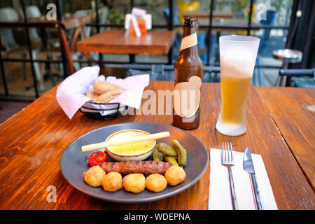 Ristorante La tabella Set di salsicce fatte a mano, salsa speciale e birra Foto Stock