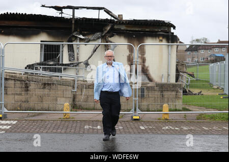 Leader laburista Jeremy Corbyn opinioni il fuoco danneggiato Woodmill High School durante una visita a Dunfermline, il primo giorno di un tour di tre giorni di circoscrizioni scozzese. Foto Stock