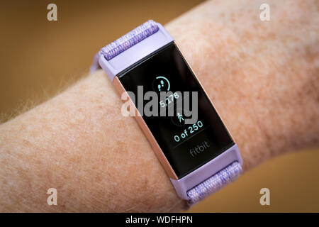 Una donna che guarda i suoi passi conta su una carica Fitbit 3 tracker fitness watch Foto Stock