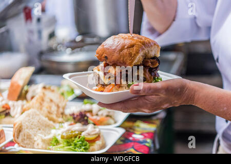 Sporco burger essendo servita presso una strada mercato alimentare Foto Stock