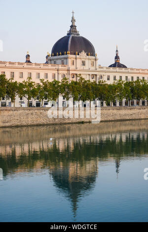 Grand Hotel-Dieu facciata riflettente nel fiume Rodano acque di sunrise, Lione, Francia Foto Stock