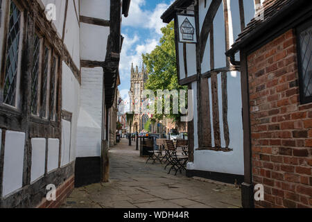 Tudor la struttura di legno bianco e nero di edifici medievali e St Marys chiesa nel pomeriggio la luce del sole. Castle Street, Warwick, Warwickshire, Inghilterra Foto Stock