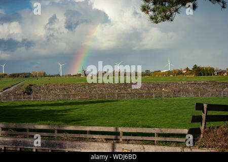 Rainbow con tradizionali e moderni mulini a vento nella campagna Olandese Foto Stock