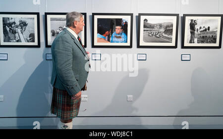 Duns, Scotland, Regno Unito. Il 29 agosto, 2019. Apertura ufficiale del nuovo Jim Clark Motorsport Museum a Duns, Berwickshire, UK. Il museo è stato inaugurato da Sir Jackie Stewart e viene azionato ma Jim Clark fiducia. Nella foto, Visitatore guardando fotografie vintage sul display. Credito: Iain Masterton/Alamy Live News Foto Stock