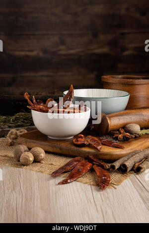 Cayenne Chili secchi cialde in una ciotola e preparazione del cibo e cucina impostazione Foto Stock