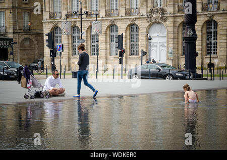 Bambina giocando in acqua specchio della Place de la Bourse di Bordeaux. Settembre 2013. Francia Foto Stock