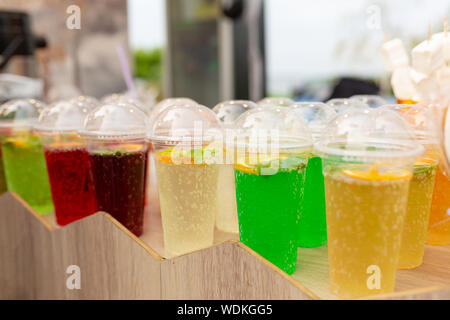 Un contatore con multi-colorati cocktail di frutta in bicchieri di plastica. Il cibo e la cucina Attrezzature in una street food festival. Foto Stock