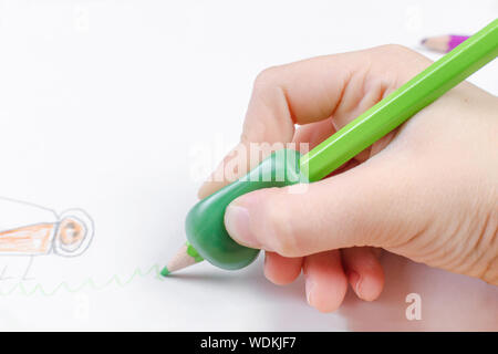 Bambino la mano con strumento di scrittura per aiutare da imperfetta tenuta di matita Foto Stock