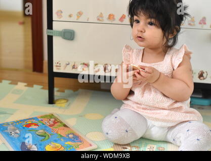 Carino bambina gioca con i pezzi del puzzle in vivaio Foto Stock