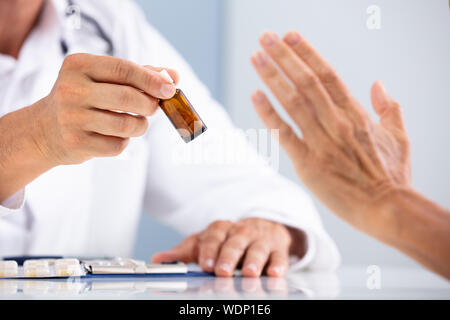 Close-up di mano di una persona che rifiuta di utilizzare farmaci detenute dal medico Foto Stock