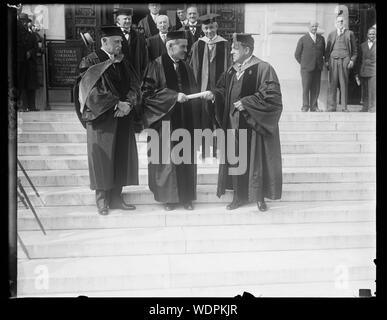 In Gran Bretagna il Primo Ministro riceve la laurea da George Washington University. Ramsey MacDonald, Primo ministro della Gran Bretagna, riceve la laurea honoris causa di dottore in legge dal Presidente Cloyd Hock Martin (destra) di George Washington University nel capitale nazionale. L'ambasciatore britannico Sir Esme Howard è sulla sinistra/astratta medio: 1 negativi : vetro 4 x 5 in. o più piccolo Foto Stock