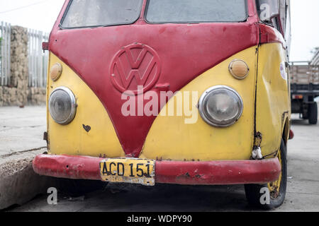 Davanti a un vecchio furgone vw arrugginito rosso e giallo Foto Stock