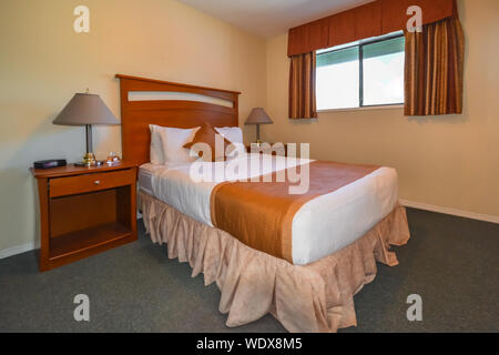 L'interno dell'albergo camera da letto con letto matrimoniale e lampade sui comodini. Foto Stock