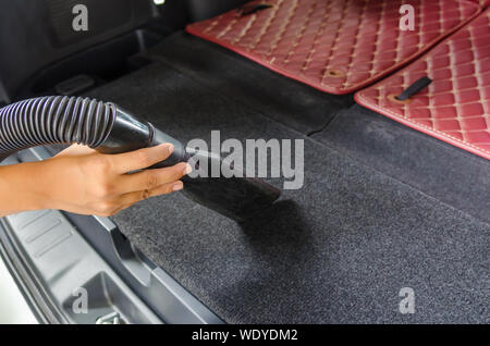 Donna hoovering una sede all'interno di un abitacolo per auto, lo sporco  visibile. Macchina per la pulizia con aspirapolvere Foto stock - Alamy