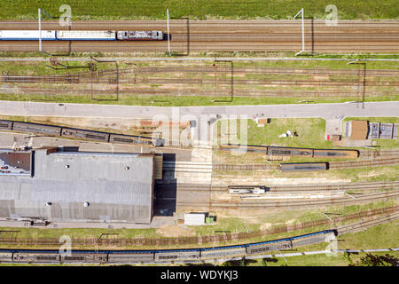 Birds Eye view di passeggeri del treno per pendolari su un binario ferroviario. Città distretto industriale Foto Stock