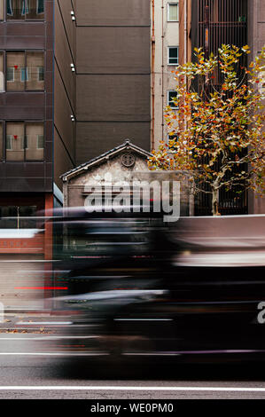 Dic 5, 2018 Tokyo, Giappone - in parte visibile della piccola vecchia casa giapponese tra gli edifici moderni in Kanda quartiere degli affari vicino al centro citta' di Tokyo con motio Foto Stock