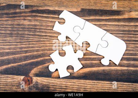 Bianco, puzzle vuota su un sfondo di legno Foto Stock