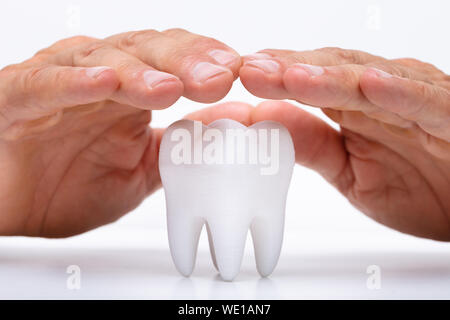 Close-up di una mano di un uomo proteggere igienicamente sano dente bianco Foto Stock