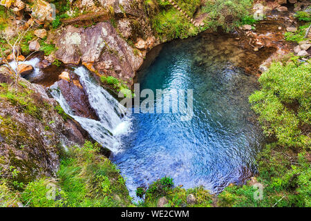 Piccolo fresco laghetto di acqua sotto la cascata sul fiume Jenolan nel profondo delle Blue Mountains vicino a caverne di Jenolan città circondata da rocce di arenaria e lussureggianti Tettoia 0 Foto Stock